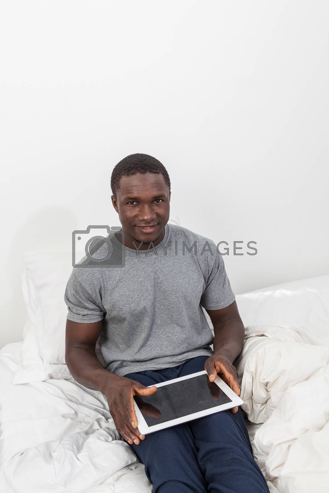 Royalty free image of Man looking at camera and touching his tablet by ifilms