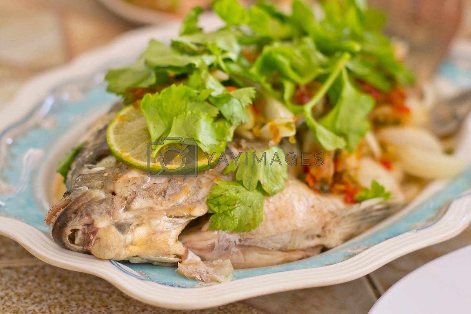 Royalty free image of Steamed Tilapia fish garnish and vegetables by Thanamat