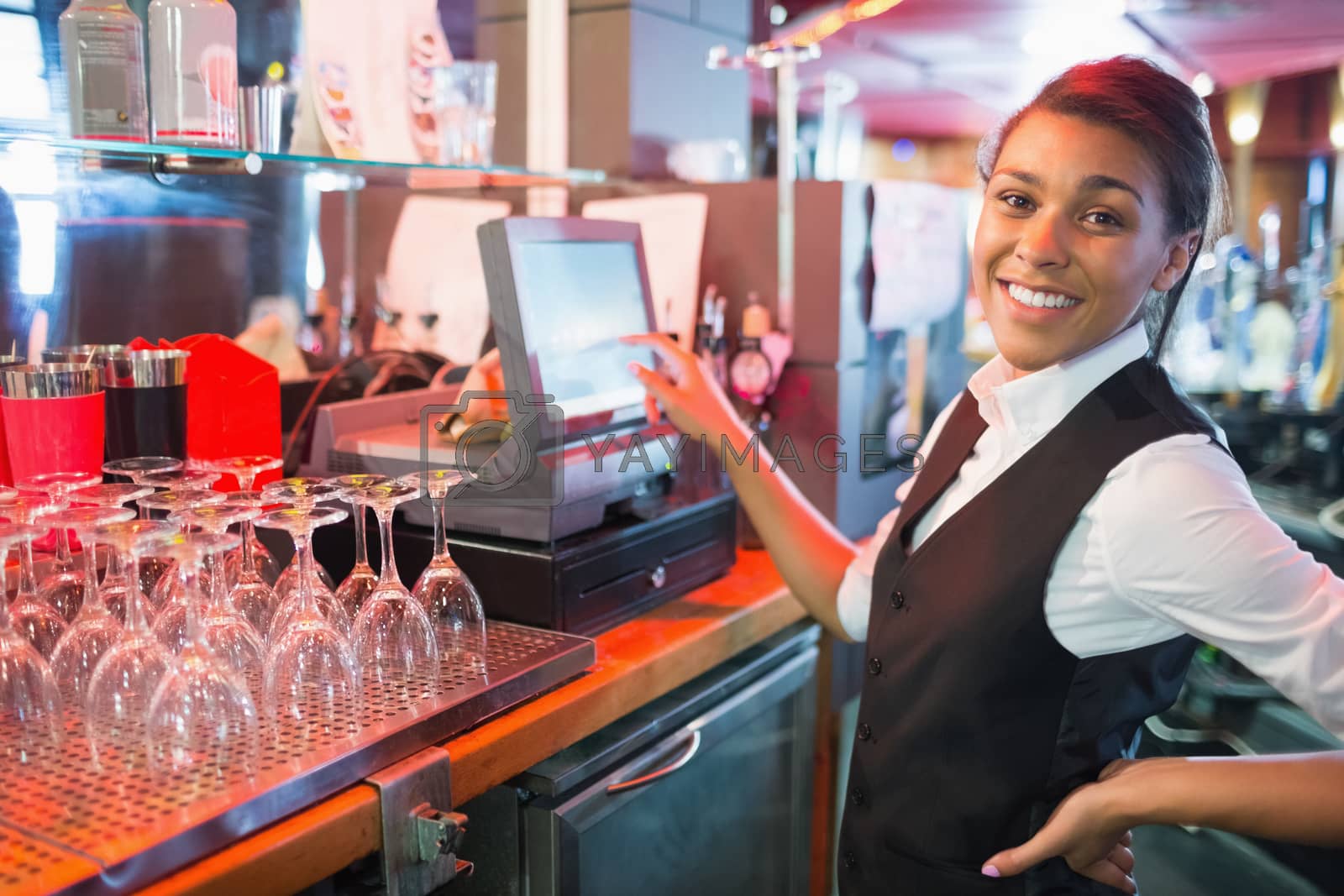 Royalty free image of Pretty barmaid using touchscreen till  by Wavebreakmedia
