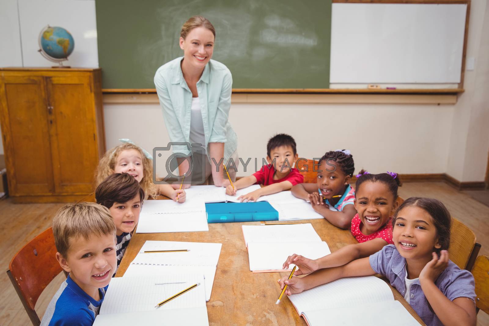 Royalty free image of Teacher and pupils working at desk together by Wavebreakmedia