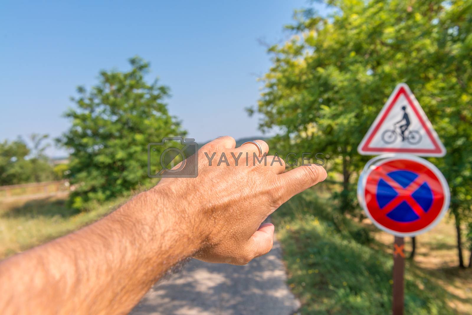 Royalty free image of Man with finger pointed to bicycle road sign by jovannig