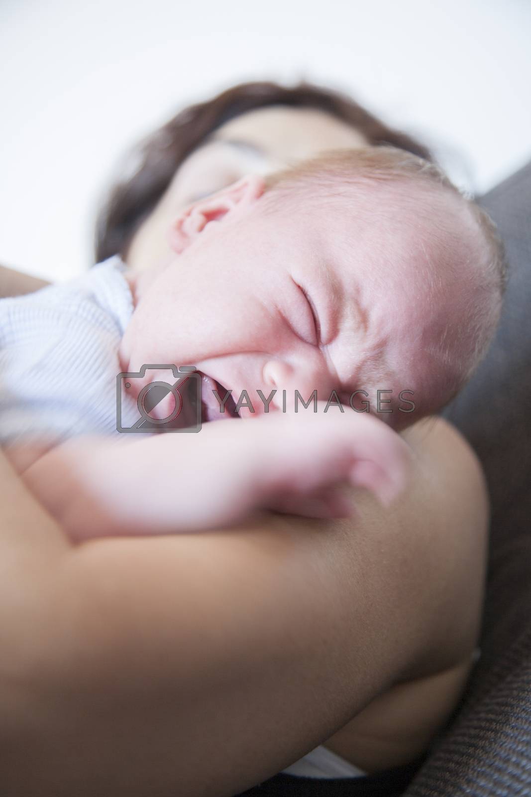 Royalty free image of newborn crying on mom shoulder by quintanilla