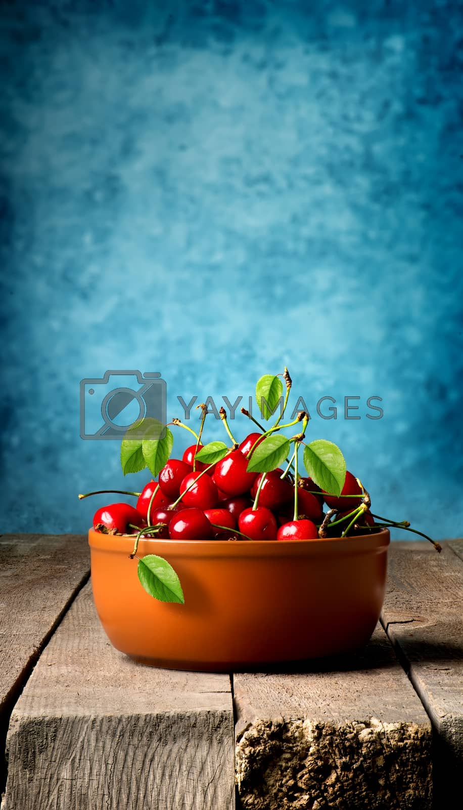 Royalty free image of Cherries in brown plate by Givaga