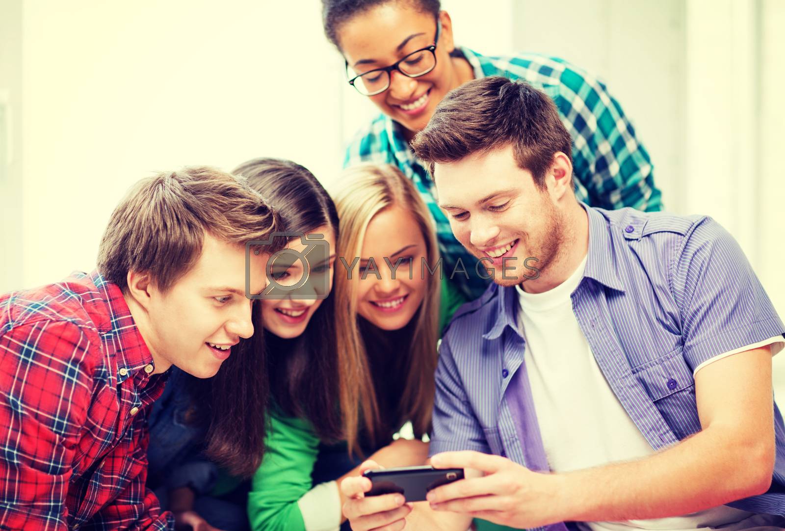 Royalty free image of students looking at smartphone at school by dolgachov
