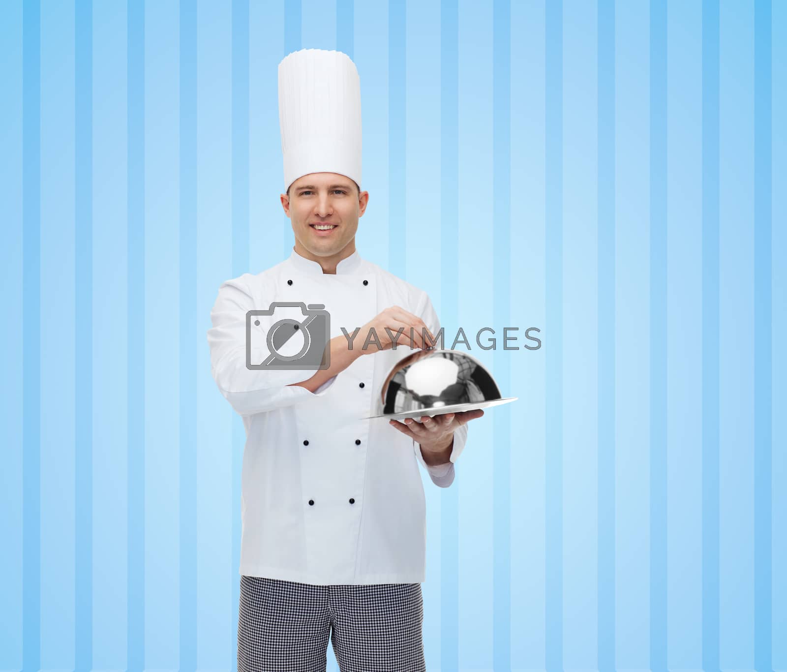Royalty free image of happy male chef cook holding cloche by dolgachov