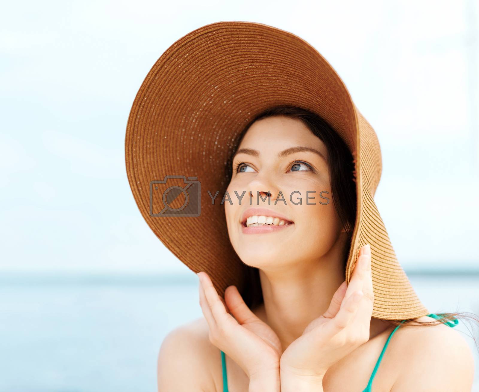 Royalty free image of girl in hat standing on the beach by dolgachov