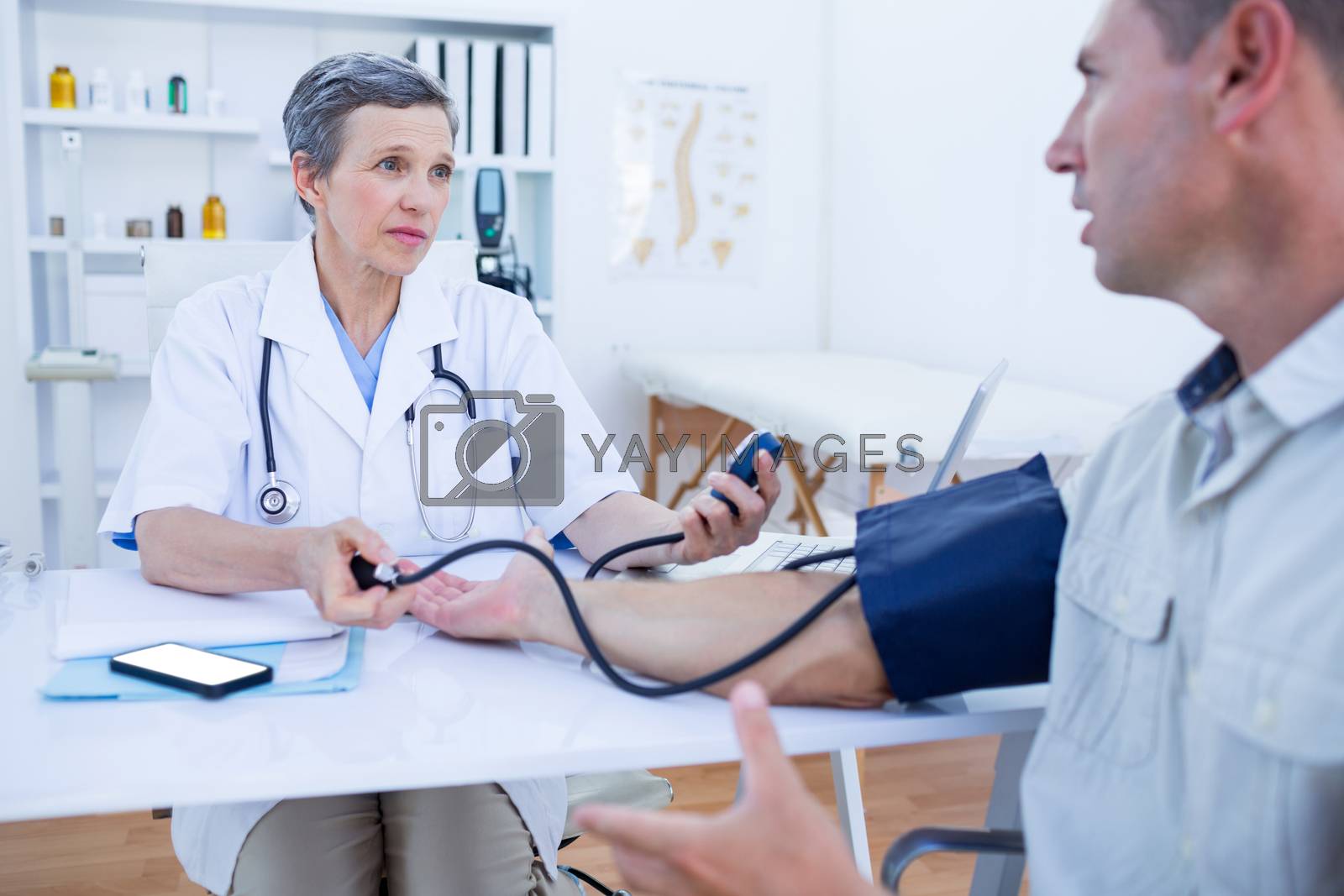 Royalty free image of Doctor checking blood pressure of her patient by Wavebreakmedia