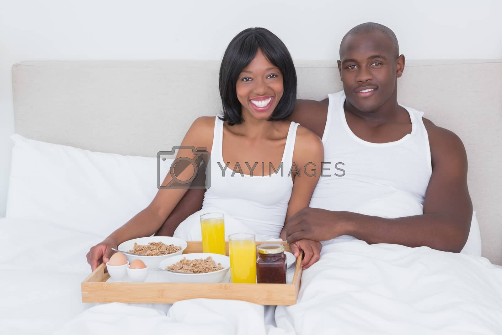 Royalty free image of Portrait of a pretty couple taking breakfast in bed together  by Wavebreakmedia
