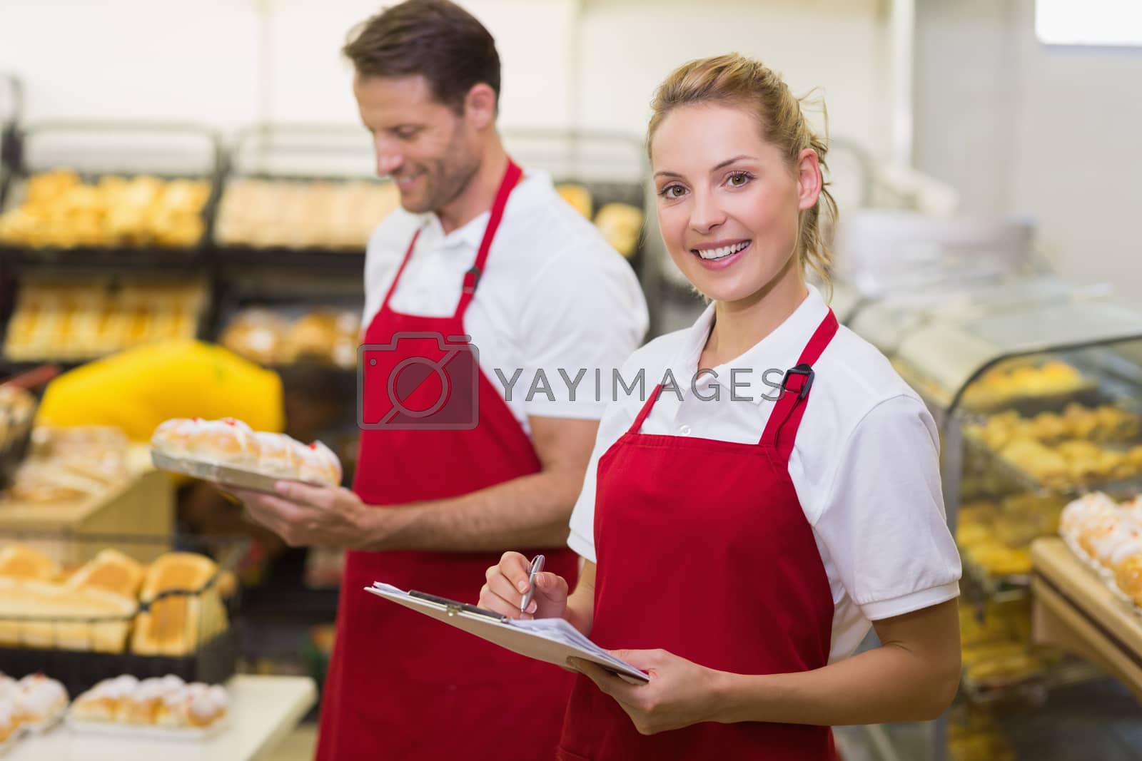 Royalty free image of Portrait of a smiling baker with her colleague by Wavebreakmedia