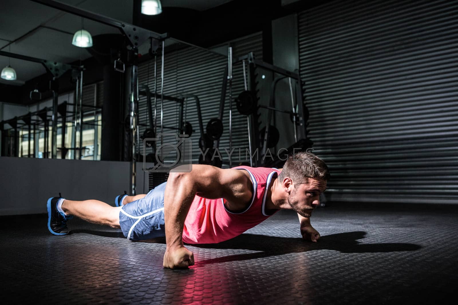 Royalty free image of Muscular man doing push-ups by Wavebreakmedia