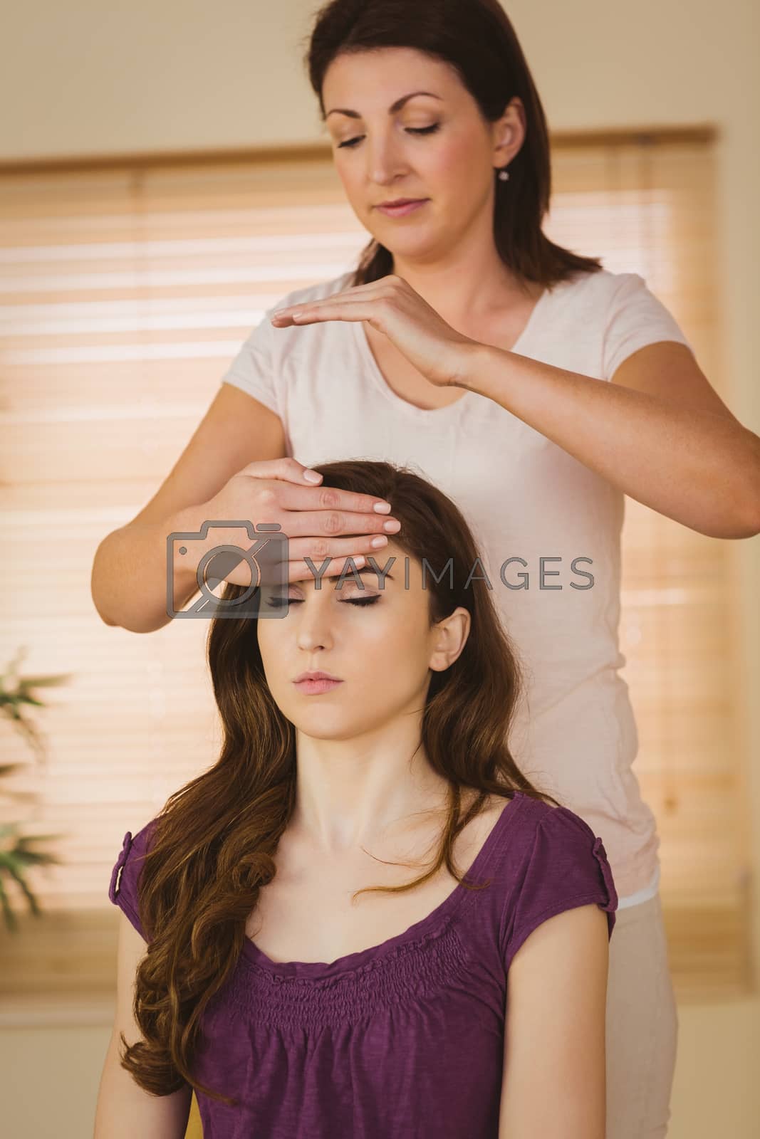 Royalty free image of Young woman having a reiki treatment by Wavebreakmedia