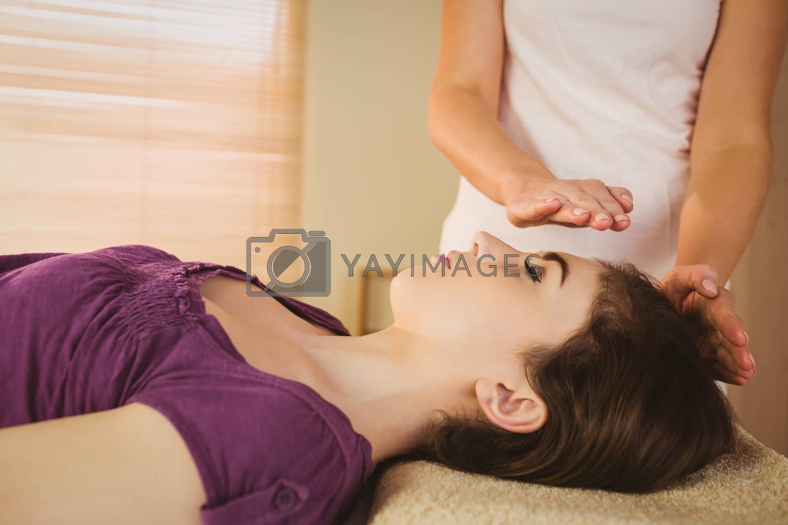 Royalty free image of Young woman having a reiki treatment by Wavebreakmedia
