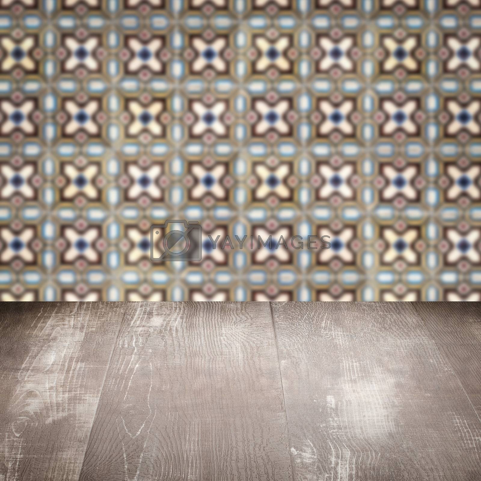 Royalty free image of Wood table top and blur vintage ceramic tile pattern wall by homydesign