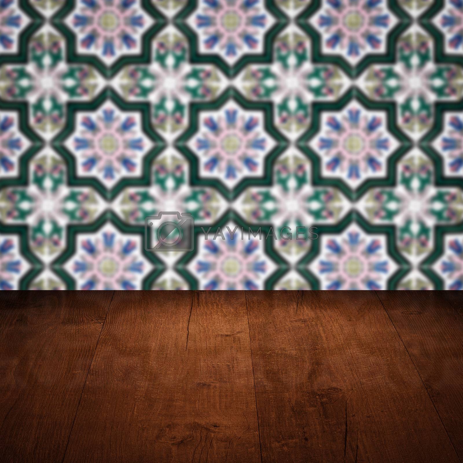 Royalty free image of Wood table top and blur vintage ceramic tile pattern wall by homydesign
