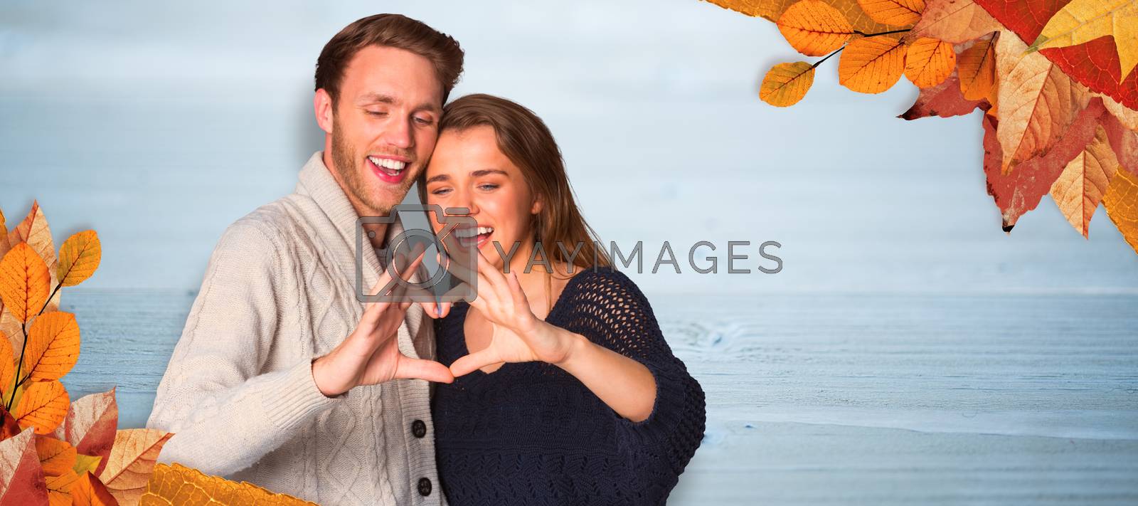 Royalty free image of Composite image of happy couple forming heart with hands by Wavebreakmedia