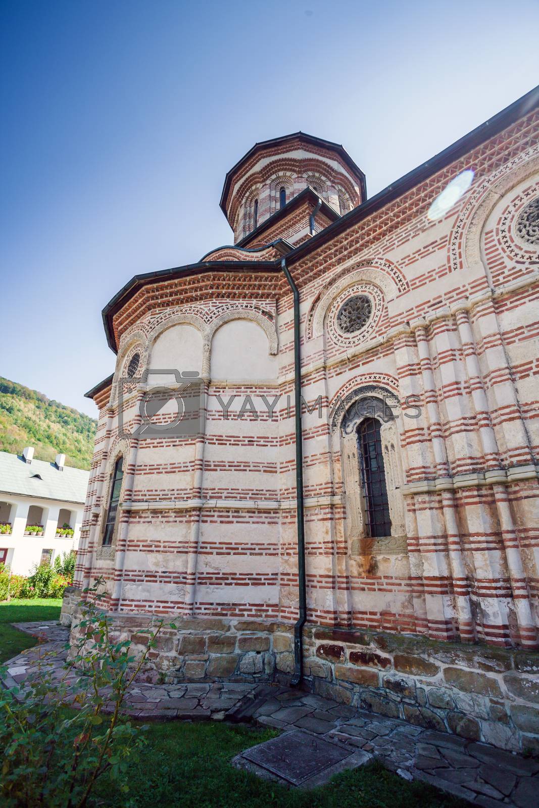 Royalty free image of Cozia monastery church with visiting tourists by PixAchi