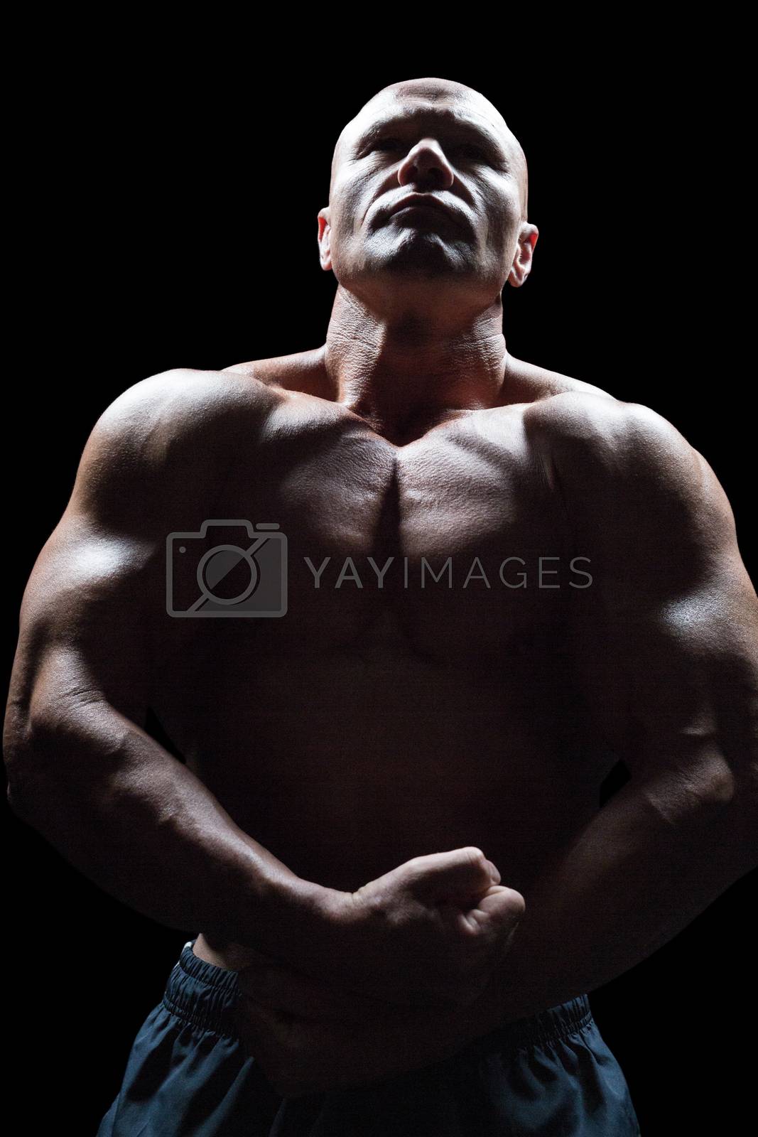 Royalty free image of Bodybuilder looking up while flexing muscles by Wavebreakmedia