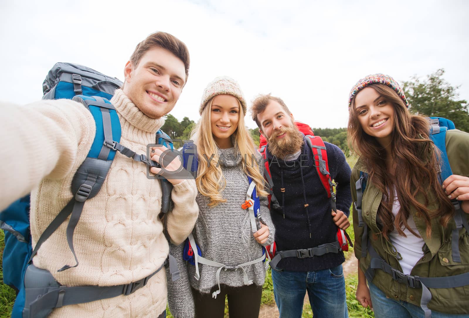 Royalty free image of group of smiling friends with backpacks hiking by dolgachov