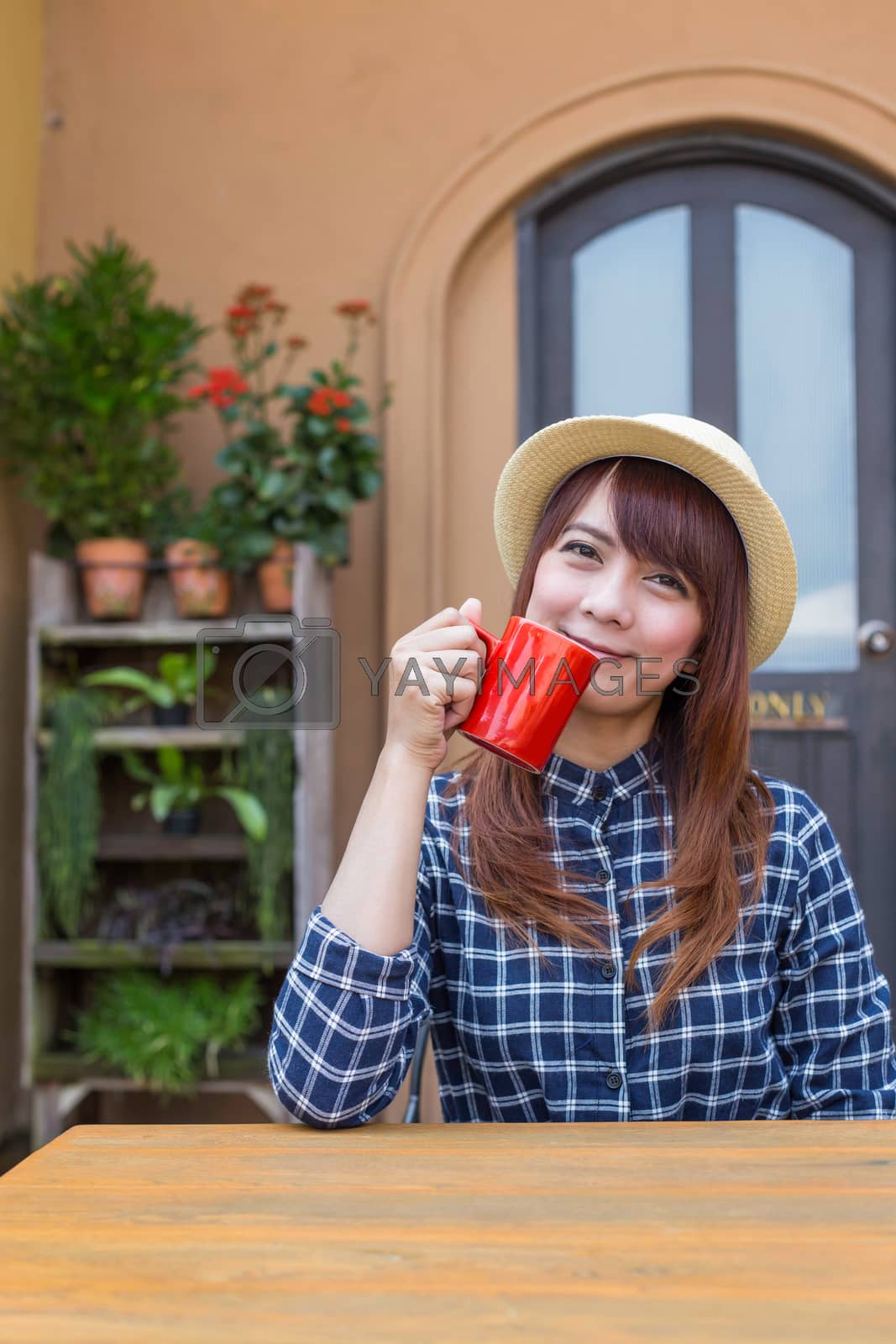 Royalty free image of wear hat woman sitting in outdoor with warm drink relax by powerbeephoto