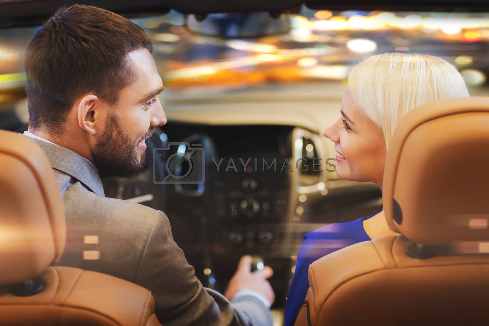 Royalty free image of happy couple driving in car over night city by dolgachov