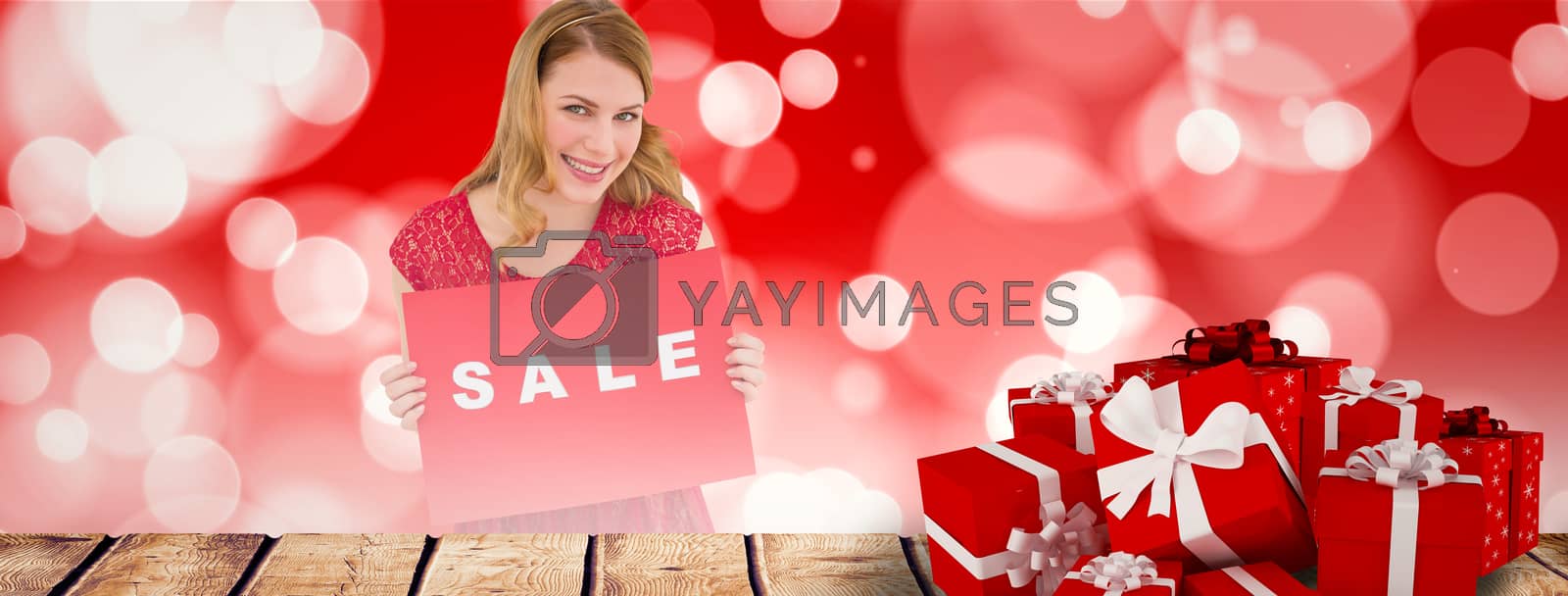 Royalty free image of Composite image of smiling blonde showing a red sale poster by Wavebreakmedia