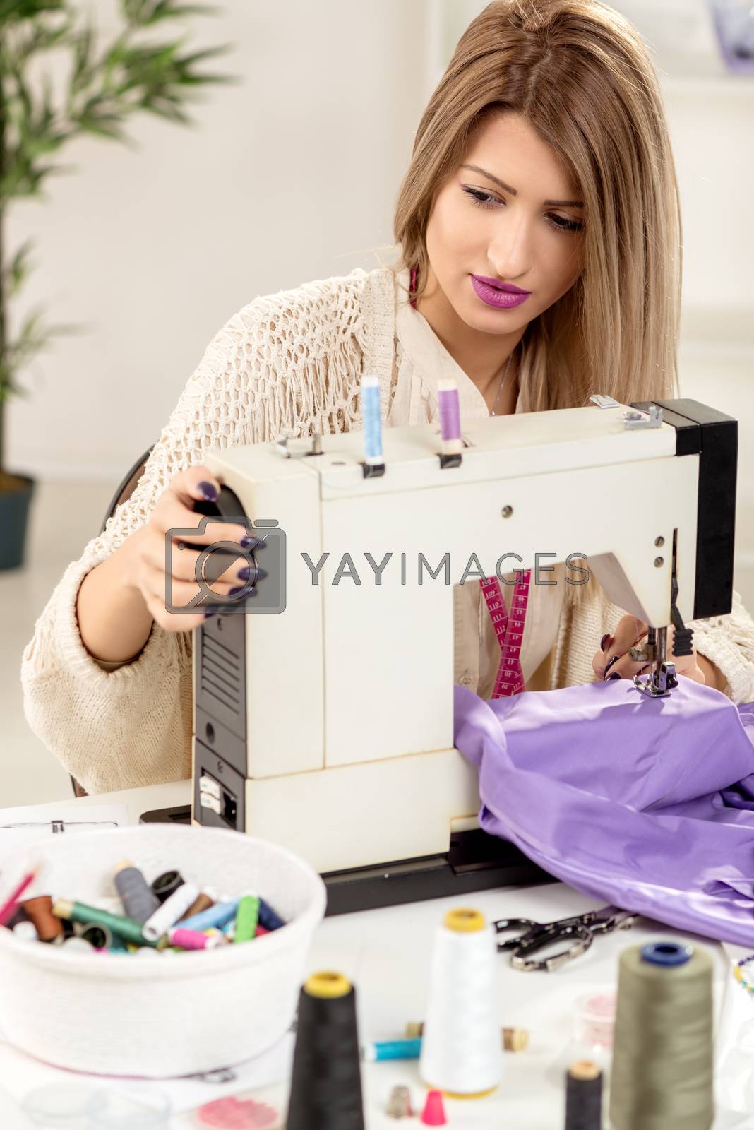 Royalty free image of Young Fashion Designer Sew by MilanMarkovic78