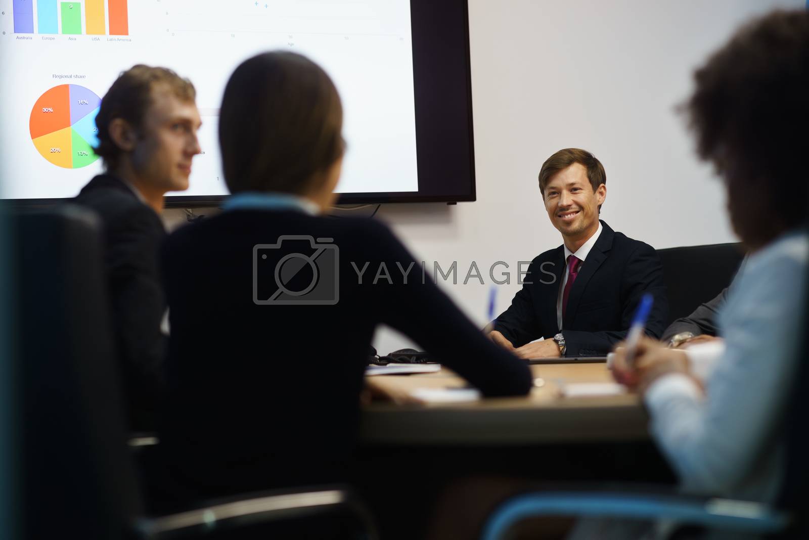 Royalty free image of Business People In Office Meeting Room With Charts On TV by diego_cervo