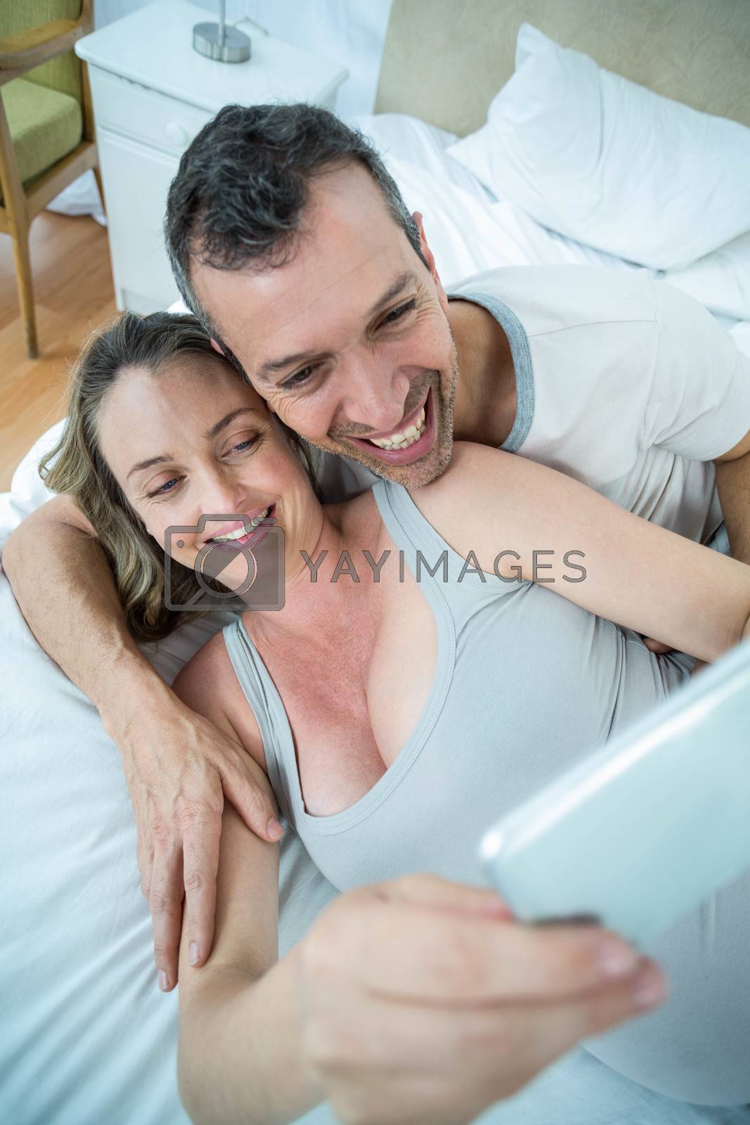 Royalty free image of Expecting couple lying on bed by Wavebreakmedia