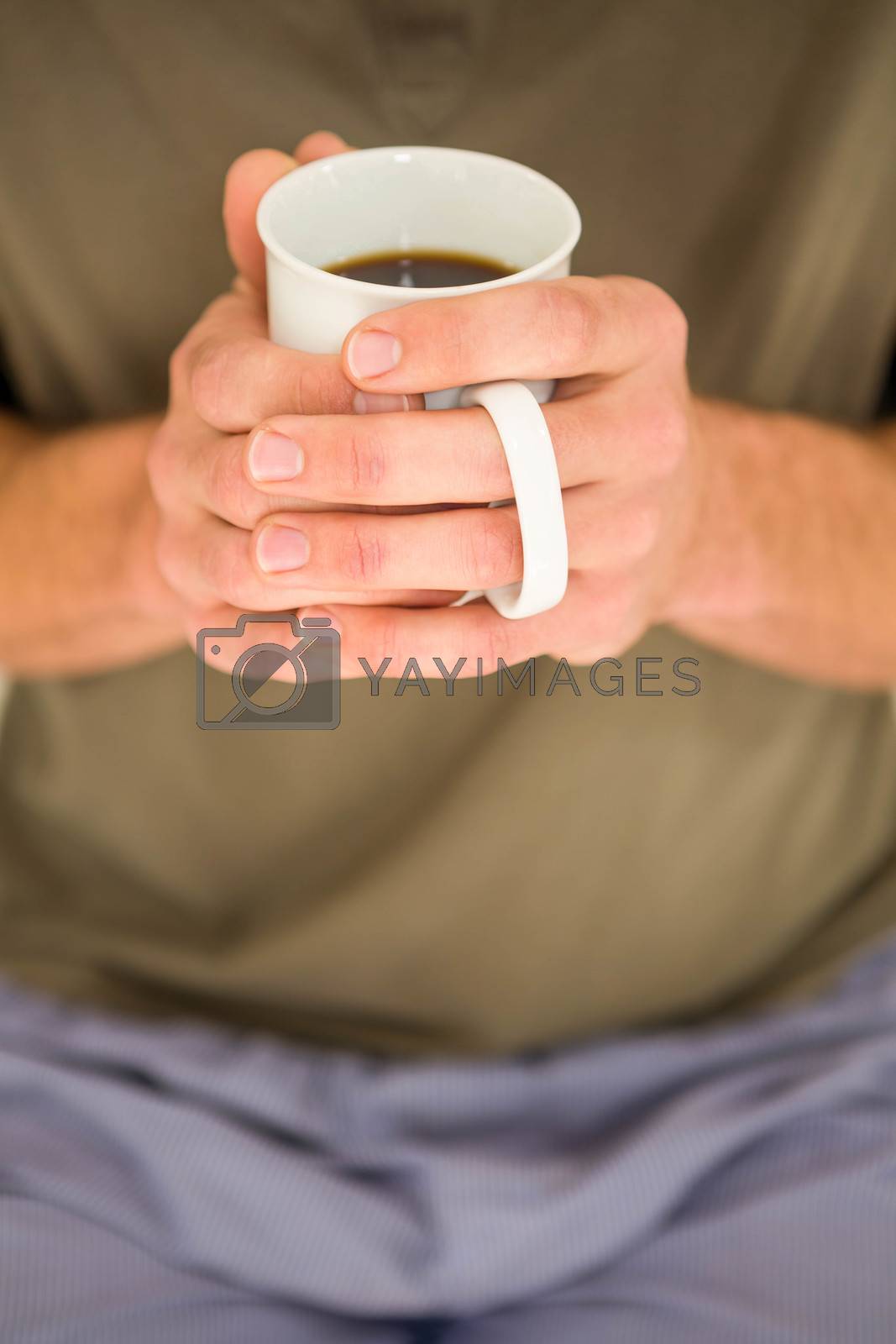 Royalty free image of Masculine hands holding a mug of tea by Wavebreakmedia