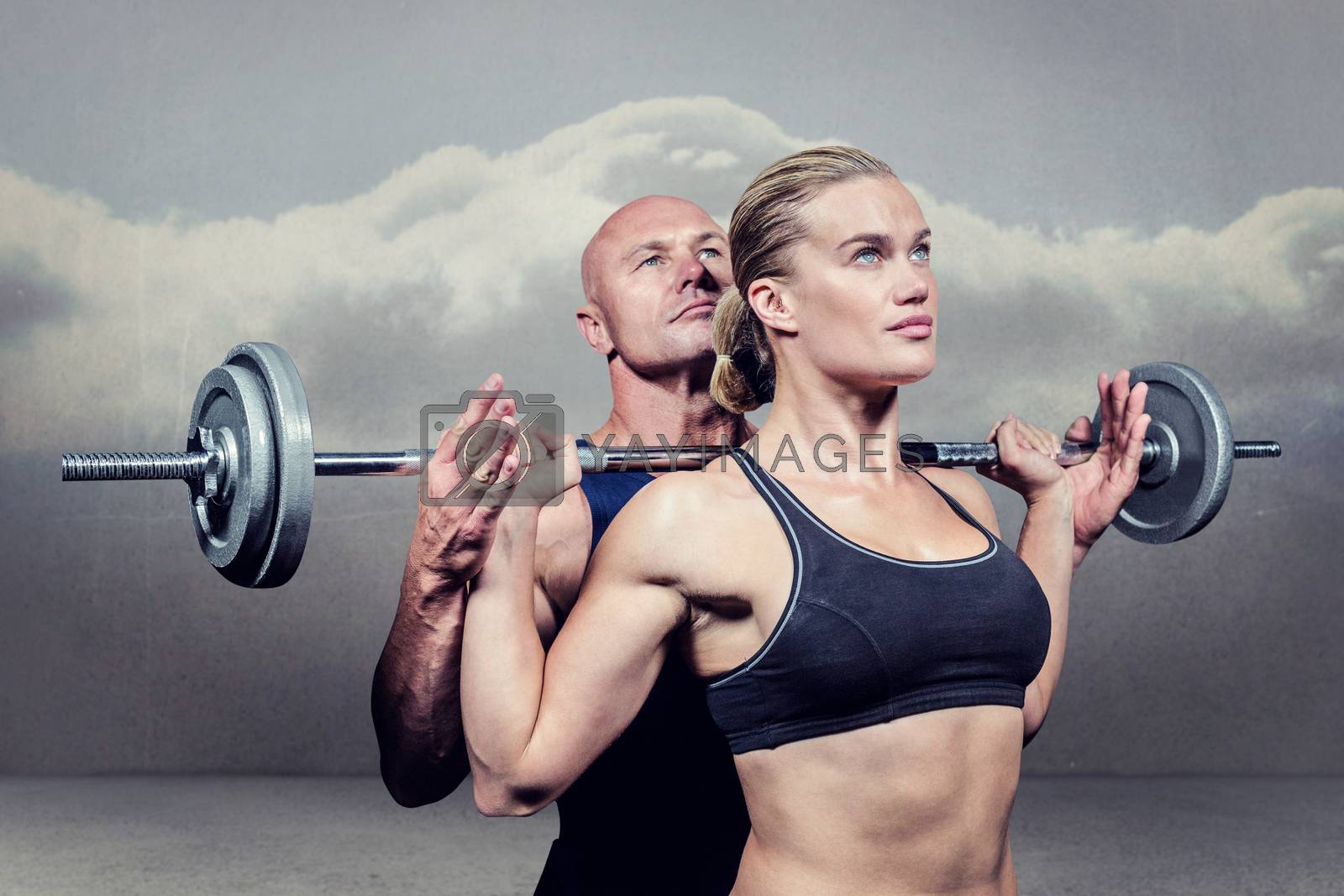 Royalty free image of Composite image of trainer helping woman for lifting crossfit by Wavebreakmedia