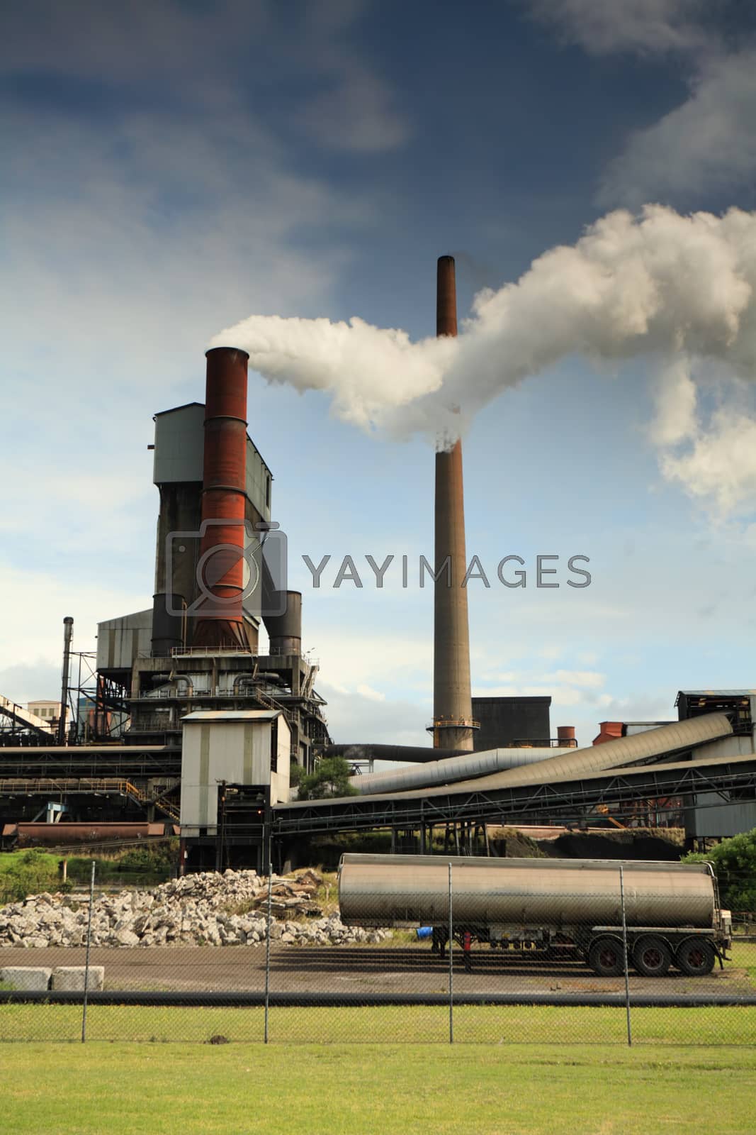 Royalty free image of Active steel mill smelter emiting billowing toxic fumes by lovleah