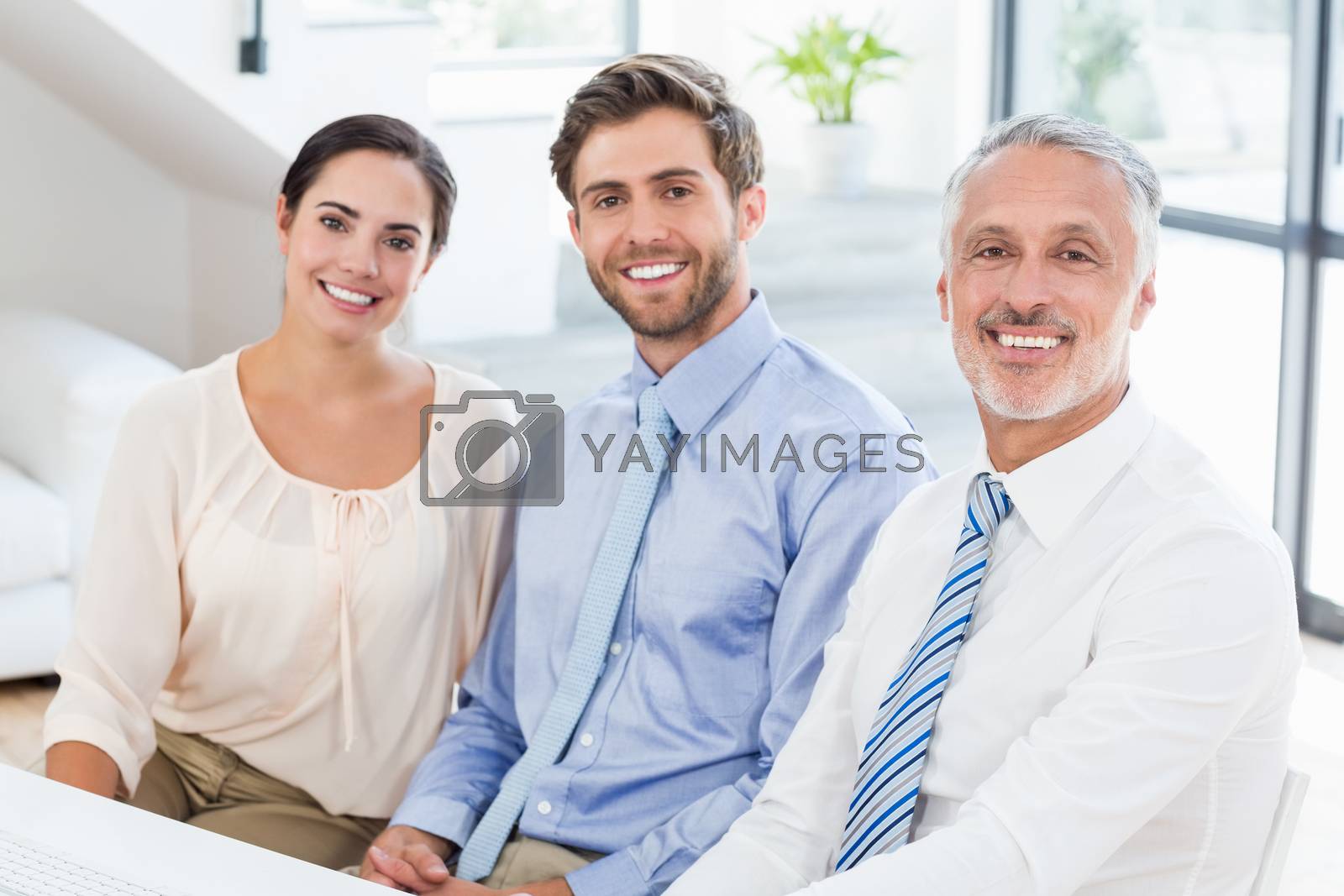 Royalty free image of Portrait of business colleagues sitting at desk by Wavebreakmedia