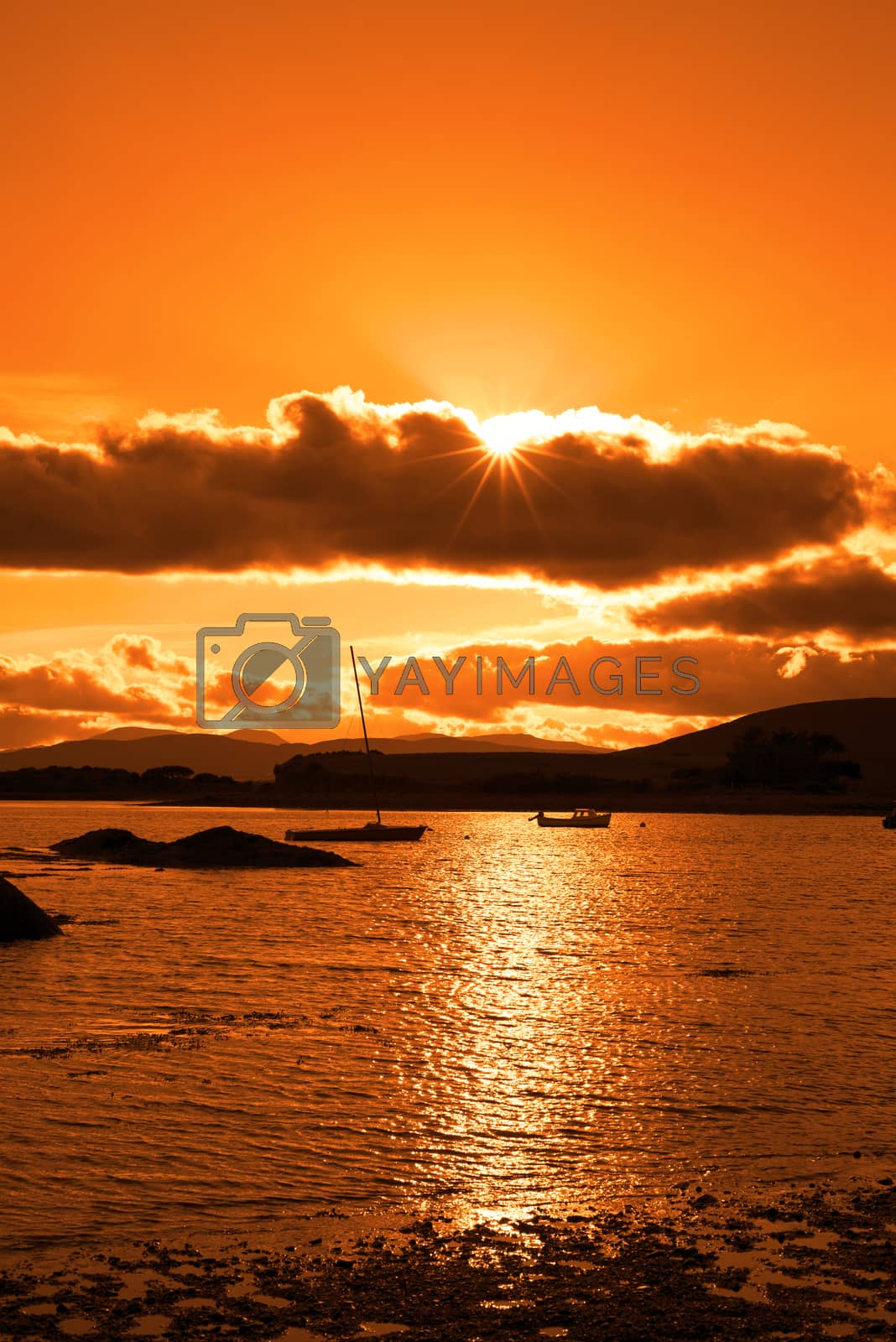 Royalty free image of boats in a quiet bay at sunset by morrbyte