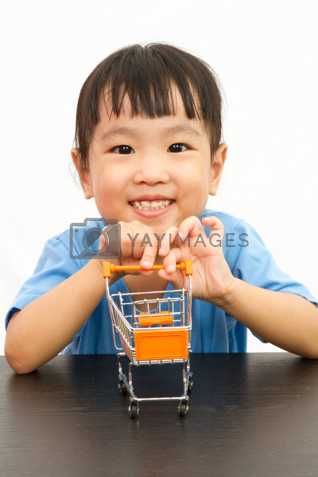 Royalty free image of Chinese little girl pushing a toy shopping cart by kiankhoon