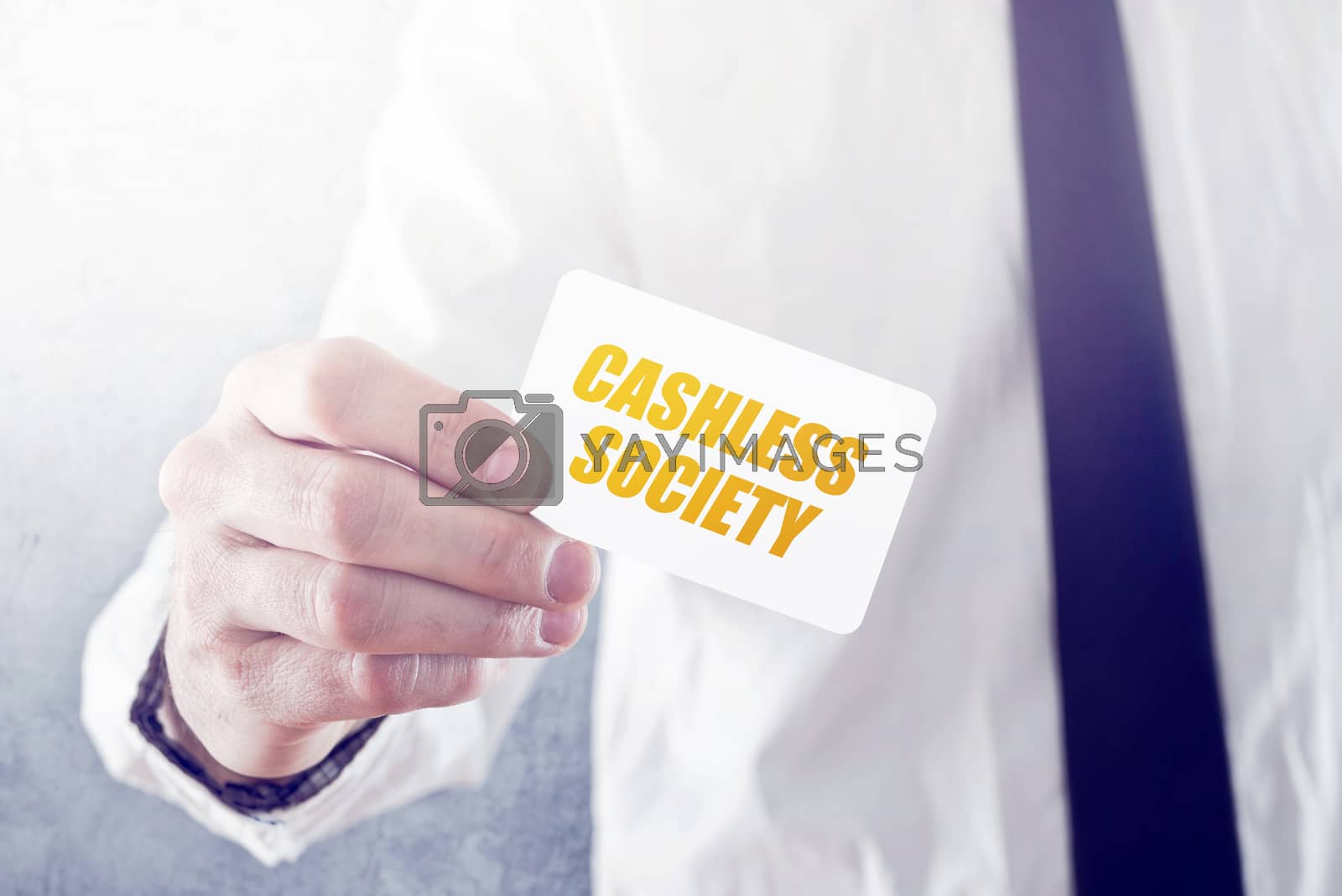 Royalty free image of Businessman holding card with Cashless society title by stevanovicigor