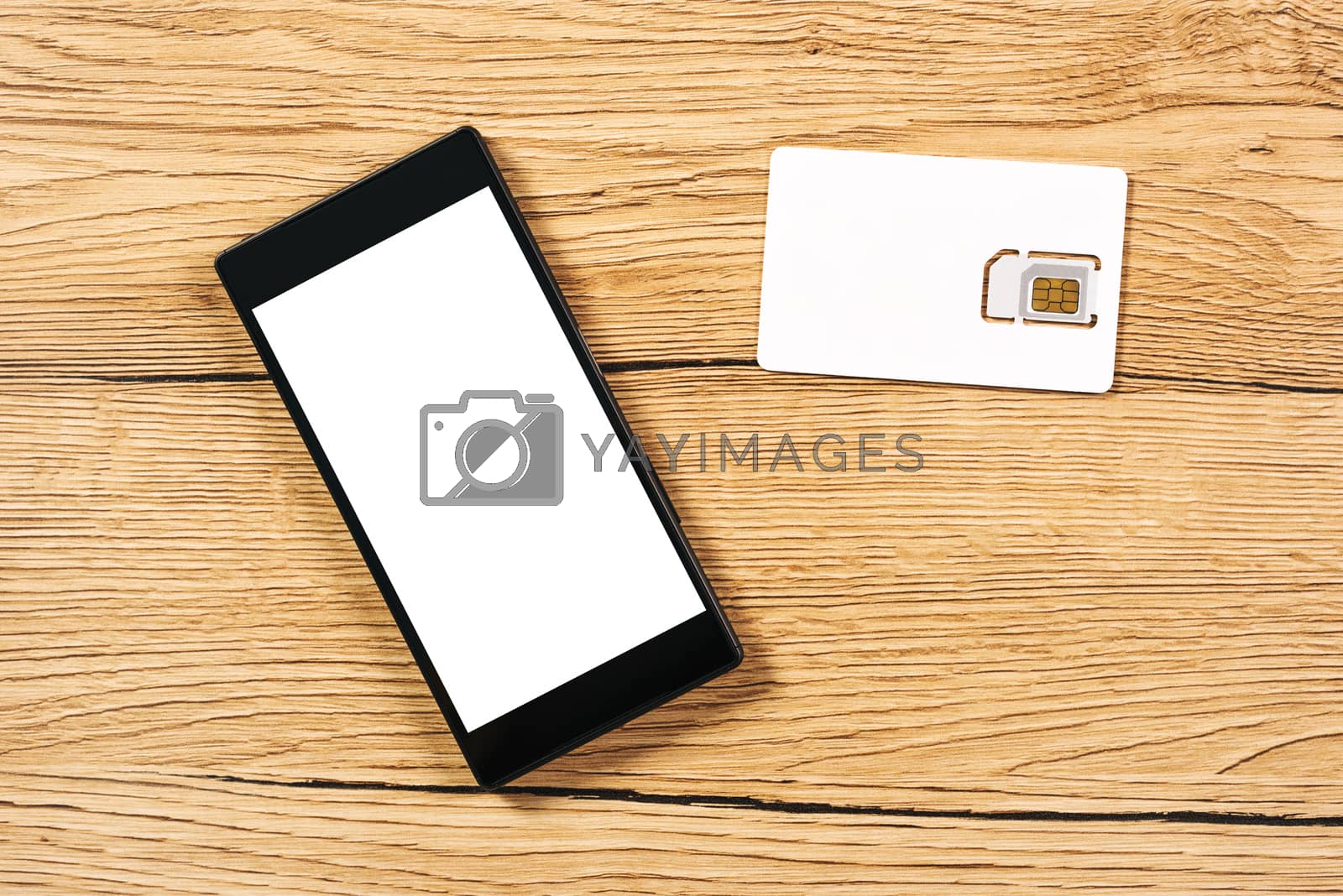 Royalty free image of Smartphone and SIM card on office table, top view by stevanovicigor