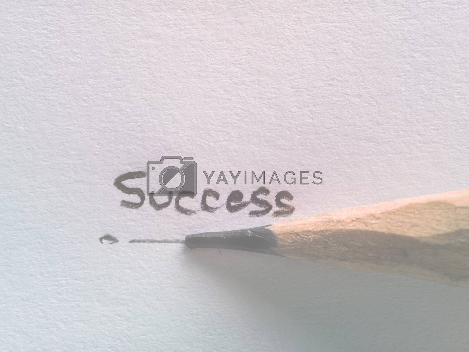 Royalty free image of Hand writing success wording on paper with pencil by hadkhanong