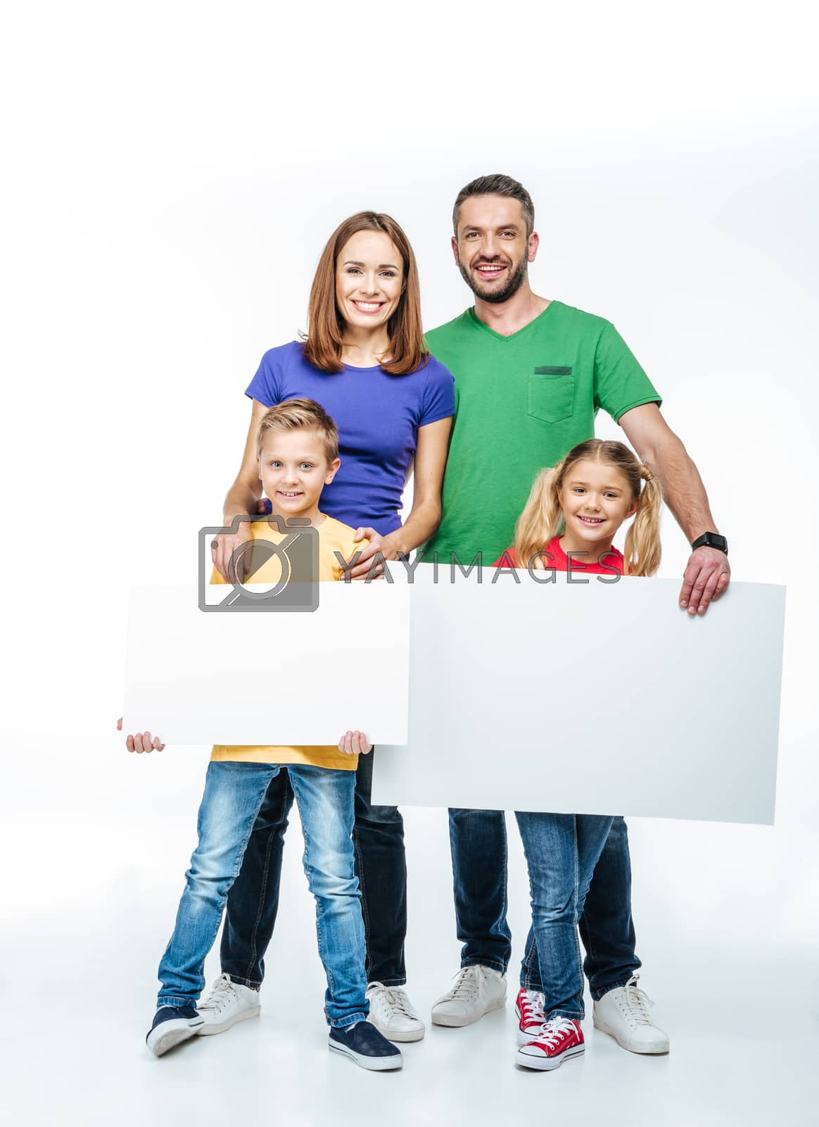 Royalty free image of family standing with blank white cards by LightFieldStudios