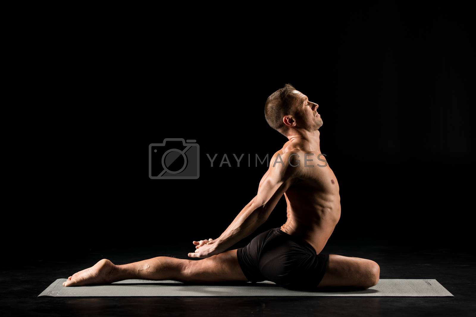 Royalty free image of Man sitting in yoga position by LightFieldStudios