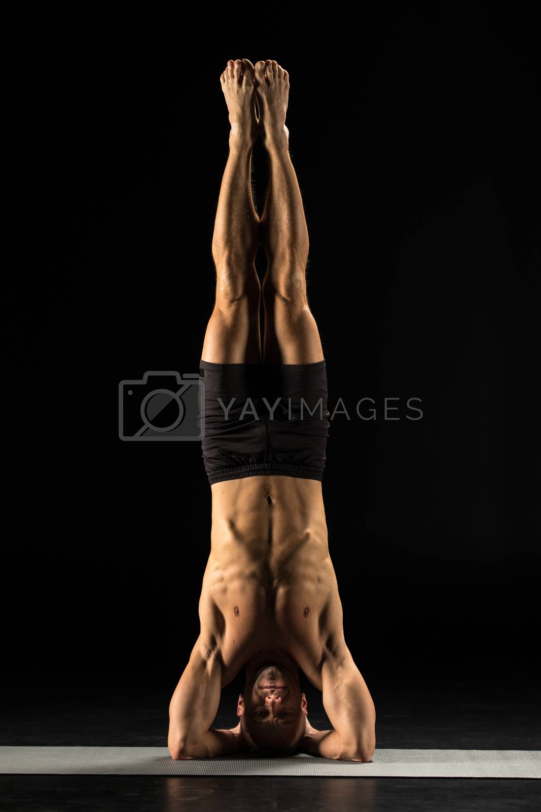 Royalty free image of Man standing in yoga position by LightFieldStudios