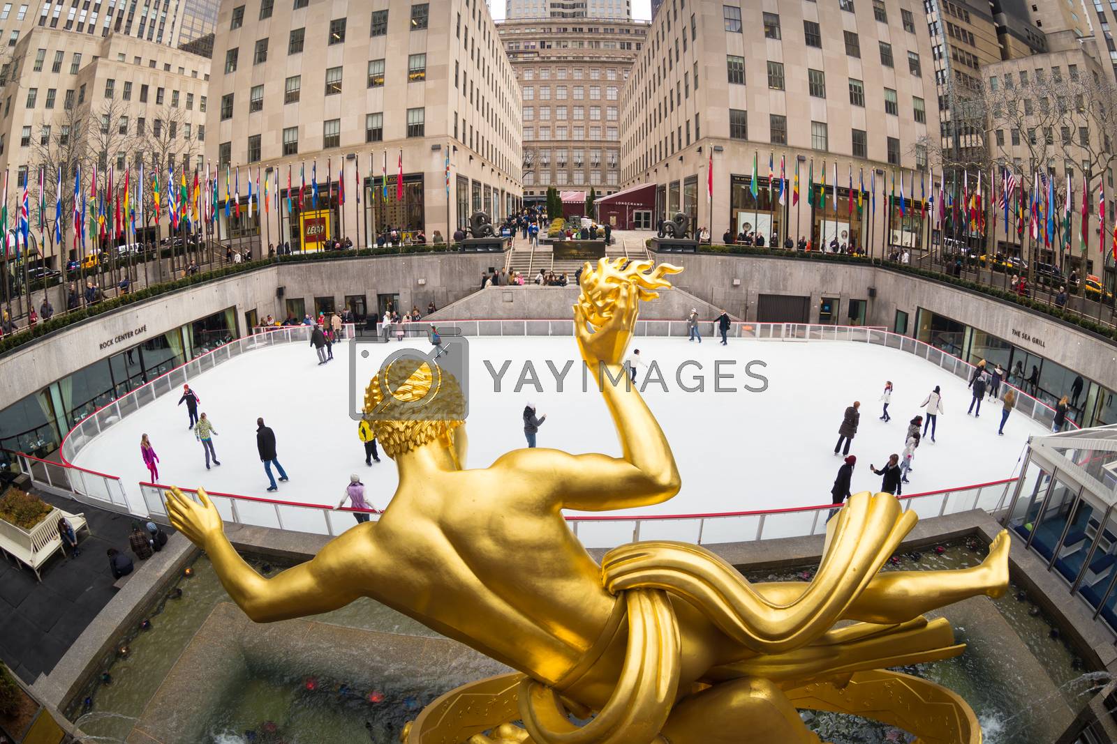 New York City, USA - March. 2015: Golden Prometheus statue and Rockefeller Center and tourists and ice skaters visiting Rockefeller Center ice skate rink on 24th of March,2015.