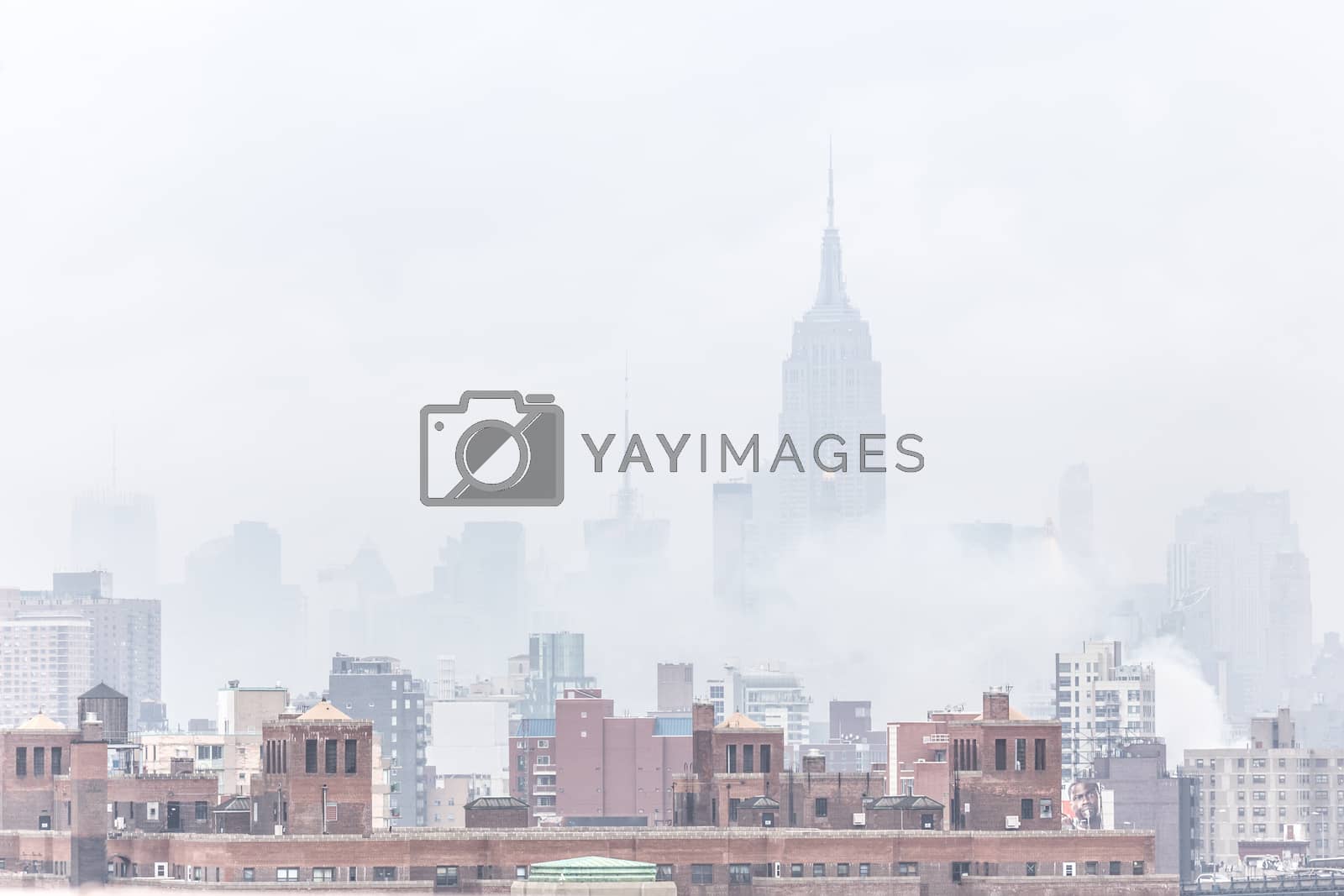 New York City, United States of America - March 24: Misty Manhattan Dimond Reef skyline with Empire State Building and skyscrapers seen from Brooklyn Bridge on March 24, 2015.