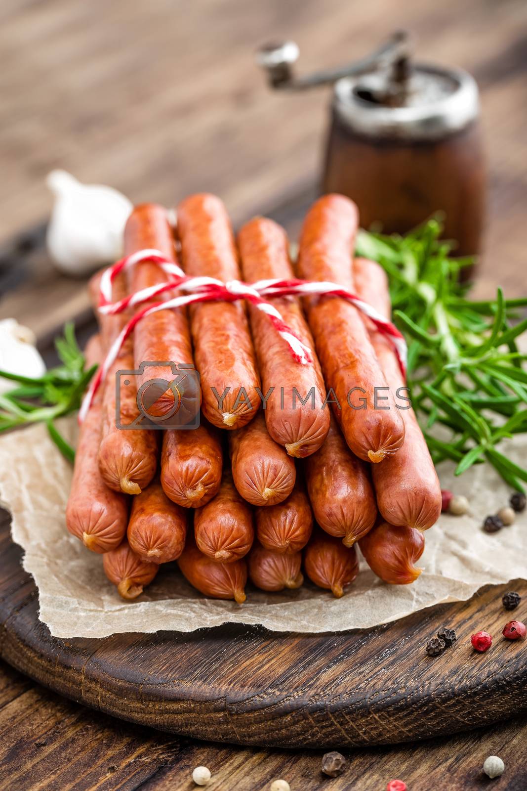 Royalty free image of Sausages on wooden background by yelenayemchuk