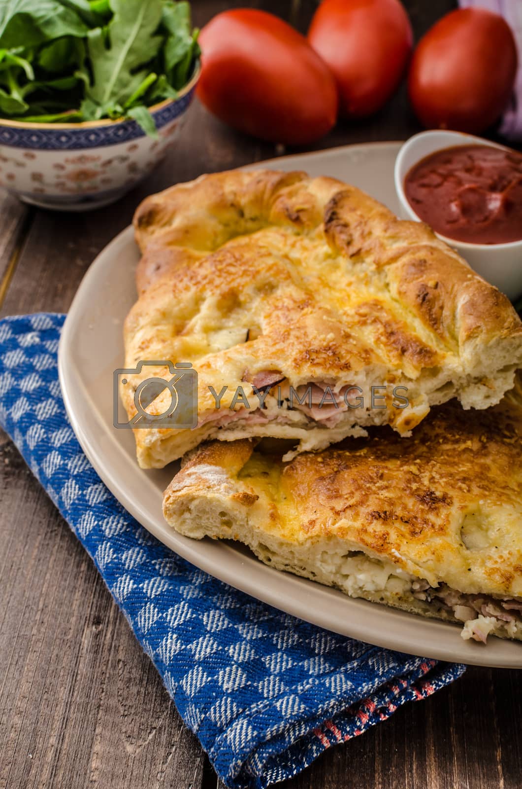 Royalty free image of Calzone pizza stuffed with cheese and prosciutto by Peteer