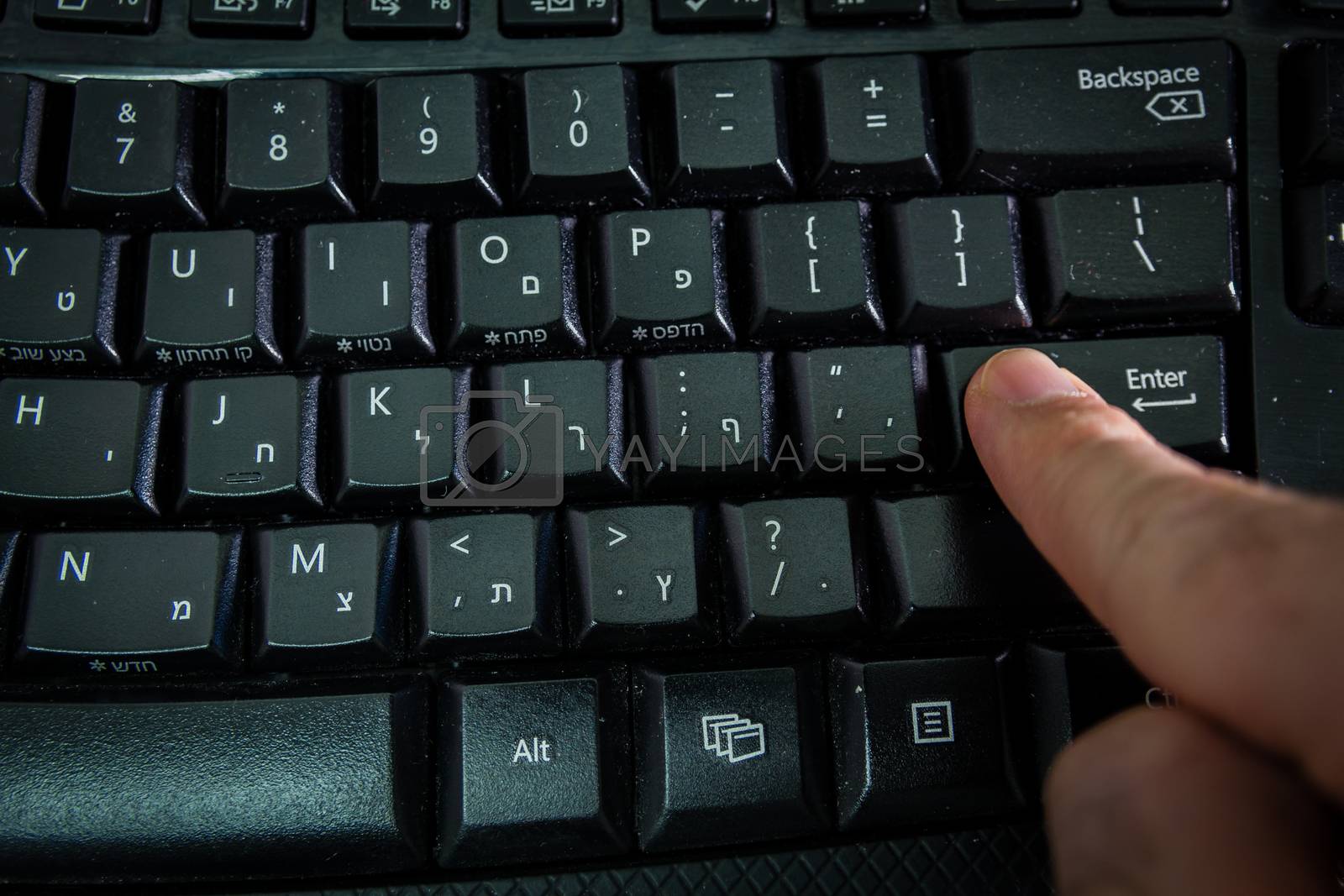 Royalty free image of Man typing on a keyboard with letters in Hebrew and English by wavemovies