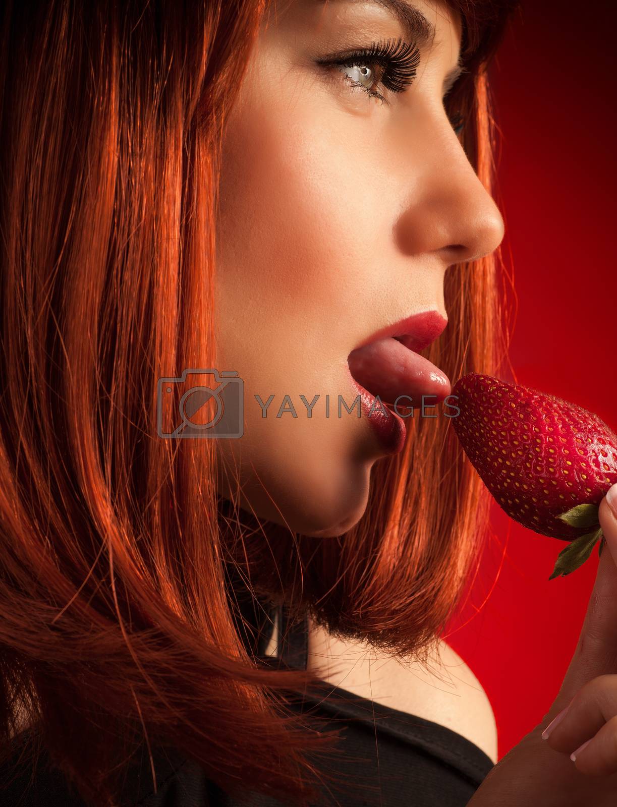 Royalty free image of Seductive woman eating strawberry by Anna_Omelchenko