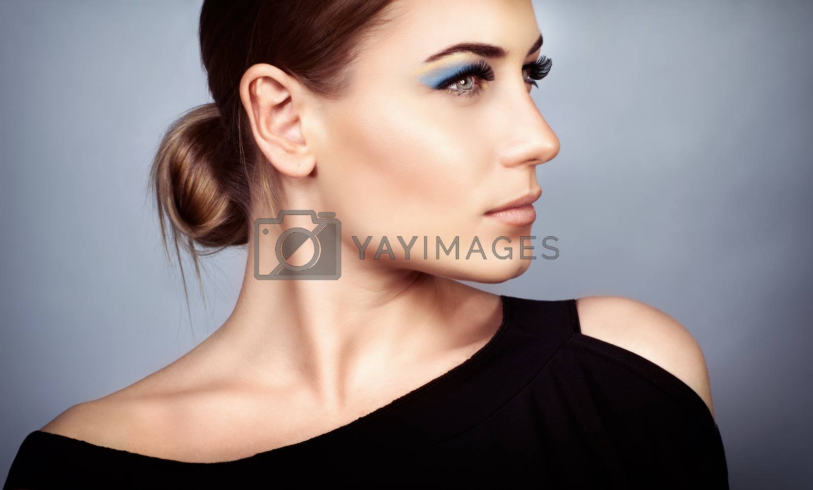 Portrait of a beautiful young woman with stylish makeup over on gray background, profile face, gorgeous fashion look