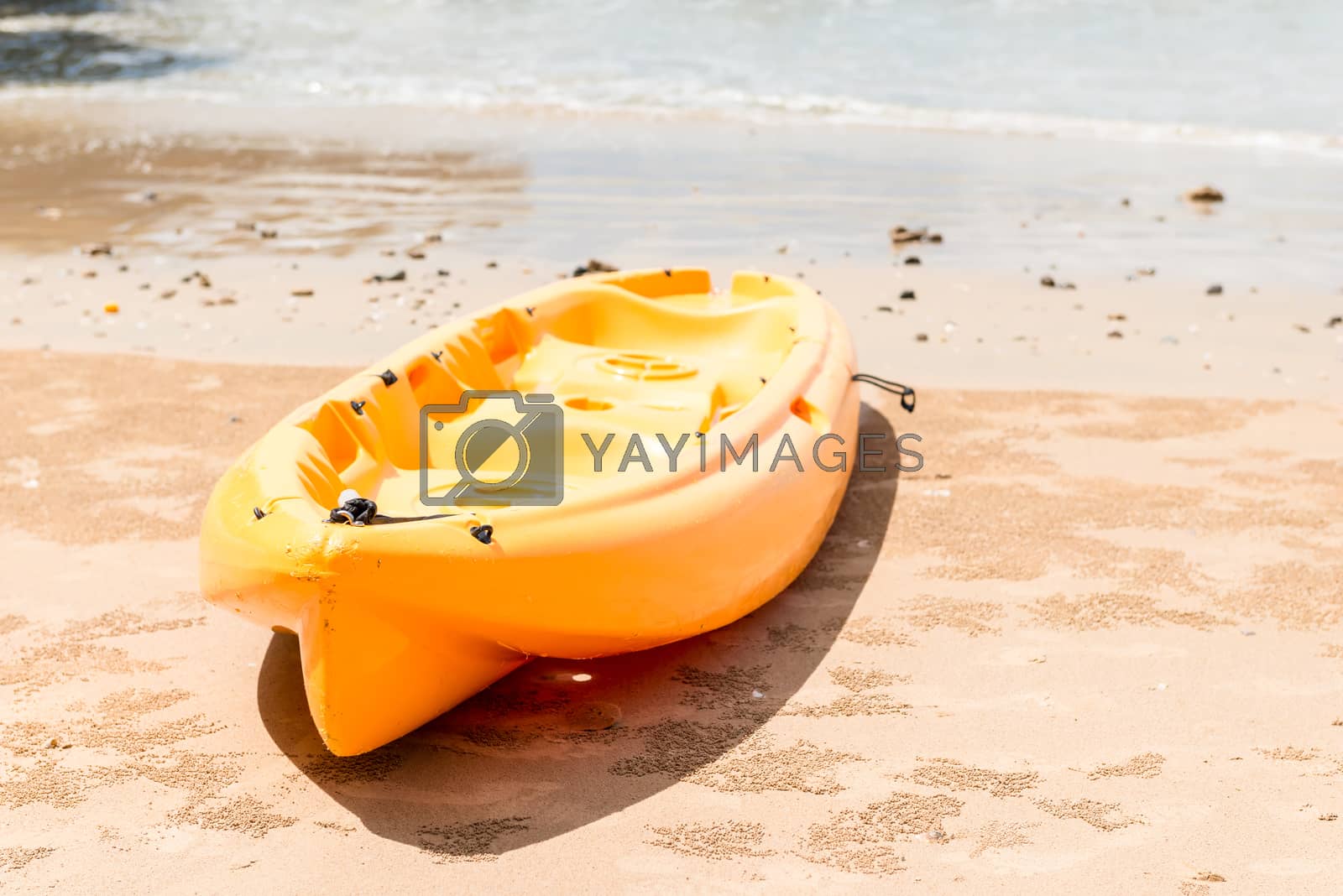 Royalty free image of a kayak for active sports on the water lies on a sandy beach by kosmsos111