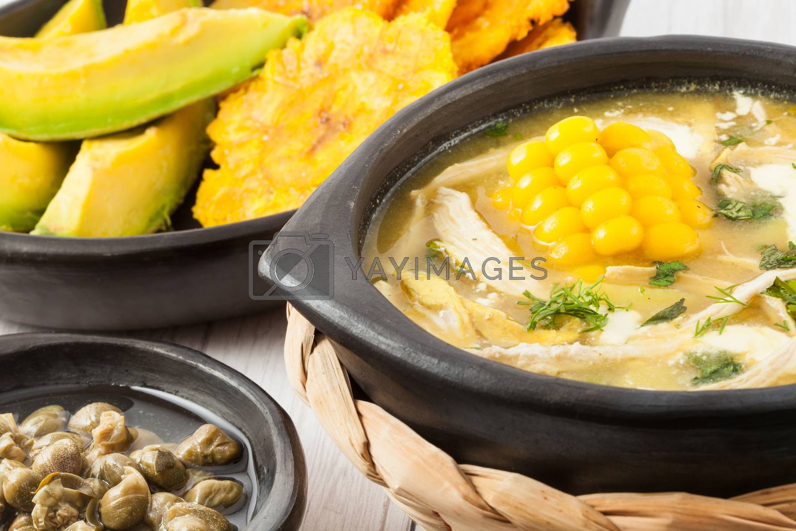 Royalty free image of Traditional Colombian ajiaco served with patacon, avocado and ca by anamejia18