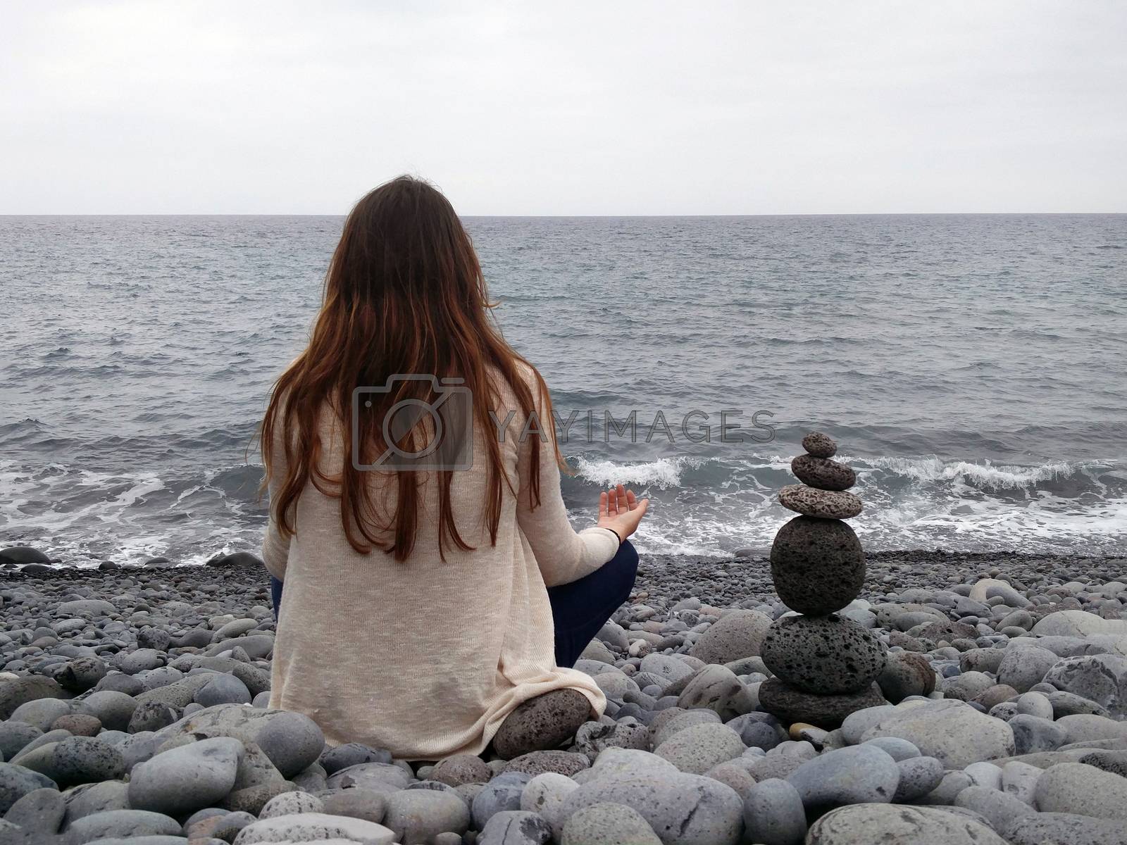 Royalty free image of girl meditating in beach by membio